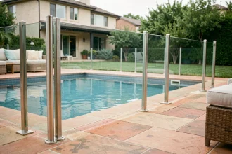 Barrière de piscine en verre trempé avec poteaux en inox autour d'une piscine résidentielle moderne dans un jardin verdoyant